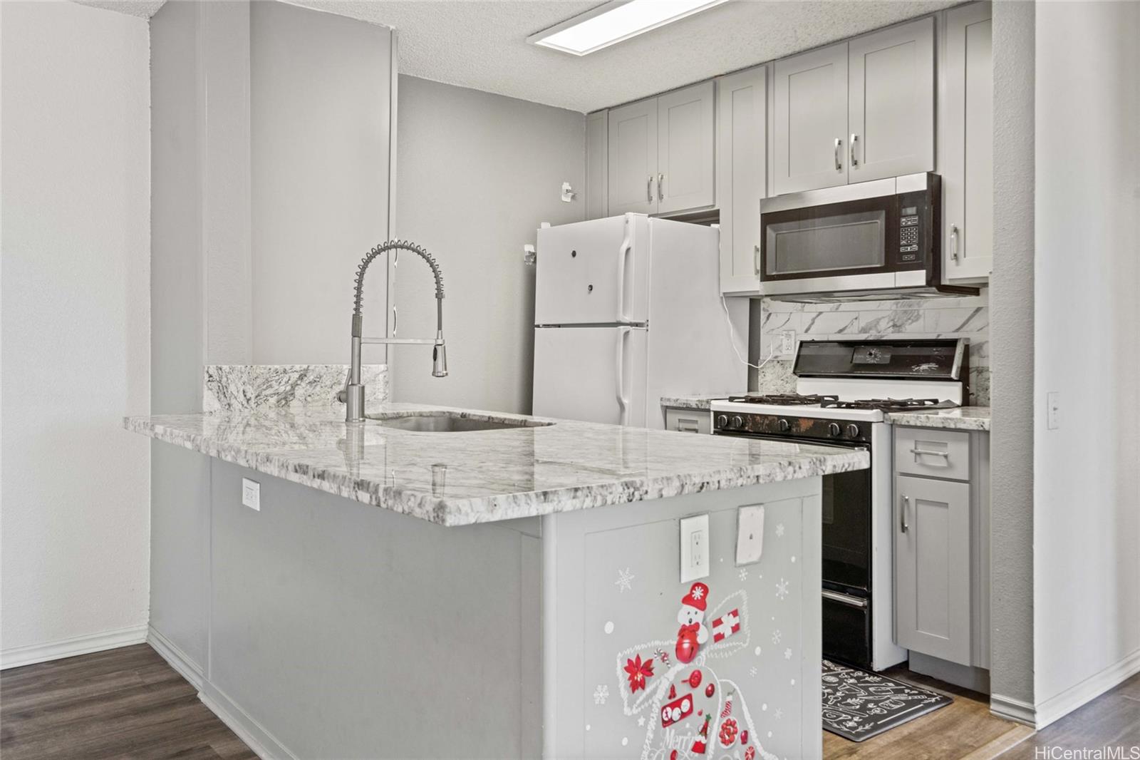 91-299 Hanapouli Circle, Unit 1C Ewa Beach, HI 96706 - Photo 3 of 25 a kitchen with granite countertop a sink stainless steel appliances and cabinets