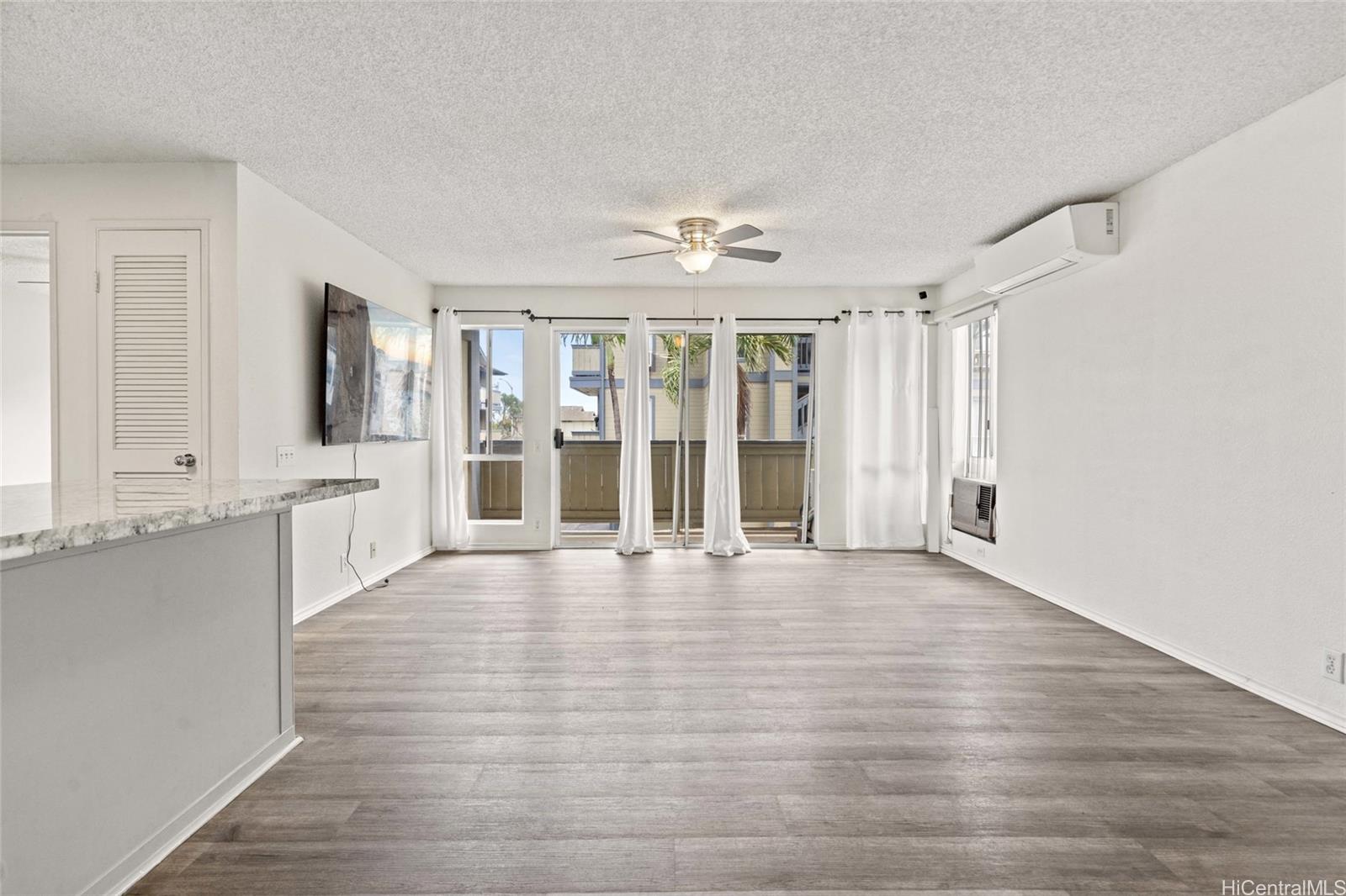 91-299 Hanapouli Circle, Unit 1C Ewa Beach, HI 96706 - Photo 10 of 25 a view of an empty room with wooden floor and a window