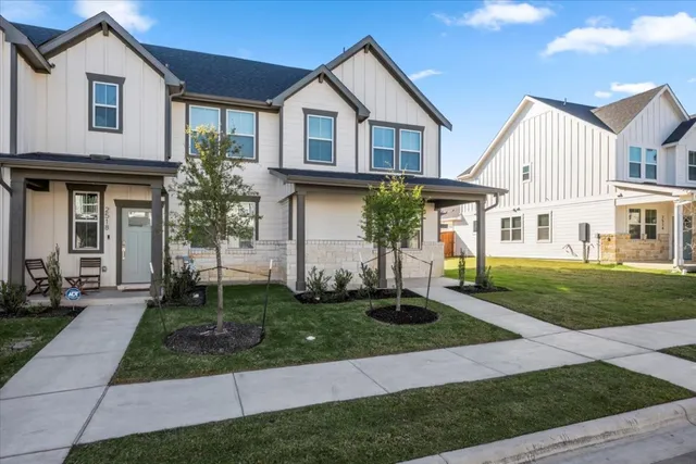 a front view of a house with a yard and potted plants
