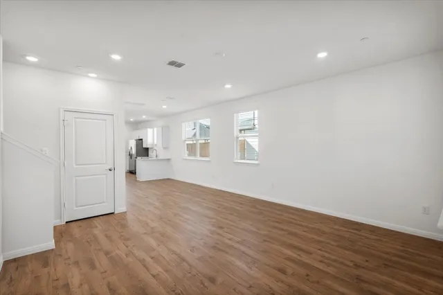 a view of a livingroom with wooden floor and windows
