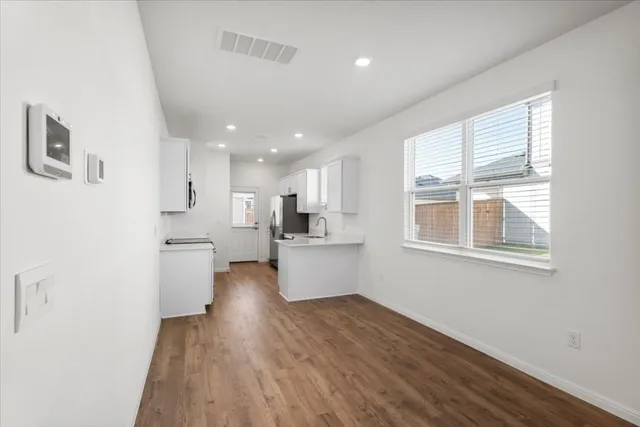 a kitchen with a refrigerator and white cabinets