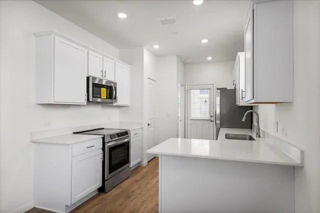 a kitchen with kitchen island a sink stainless steel appliances and cabinets