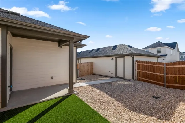 a view of a house with a yard and wooden fence