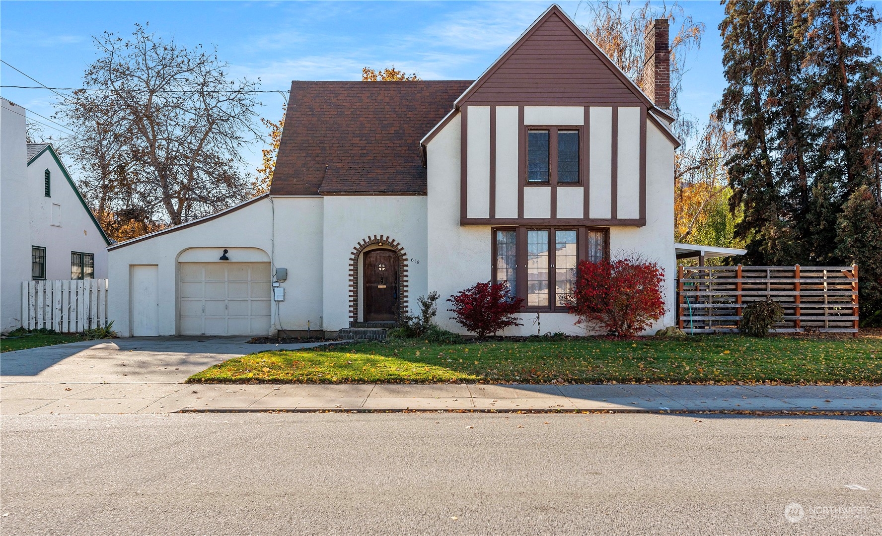 a view of house with yard and trees in the background