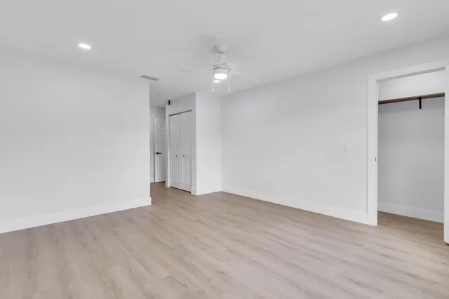 an empty room with mirror and a hallway