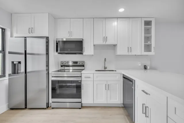 a kitchen with white cabinets and white appliances