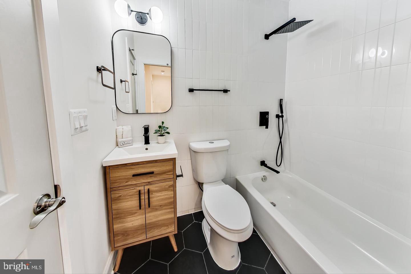 428 Evarts Street Northeast, Unit 2 Washington, DC 20017 - Photo 17 of 37 a bathroom with a toilet sink shower and mirror