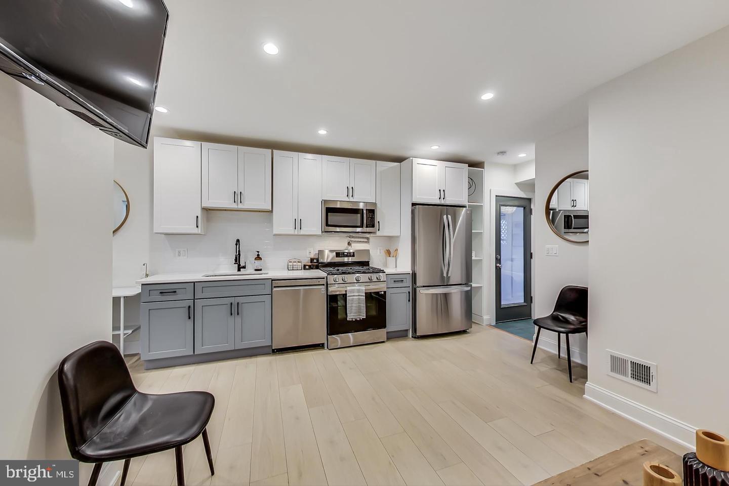 428 Evarts Street Northeast, Unit 2 Washington, DC 20017 - Photo 6 of 37 a kitchen with a refrigerator cabinets and wooden floor