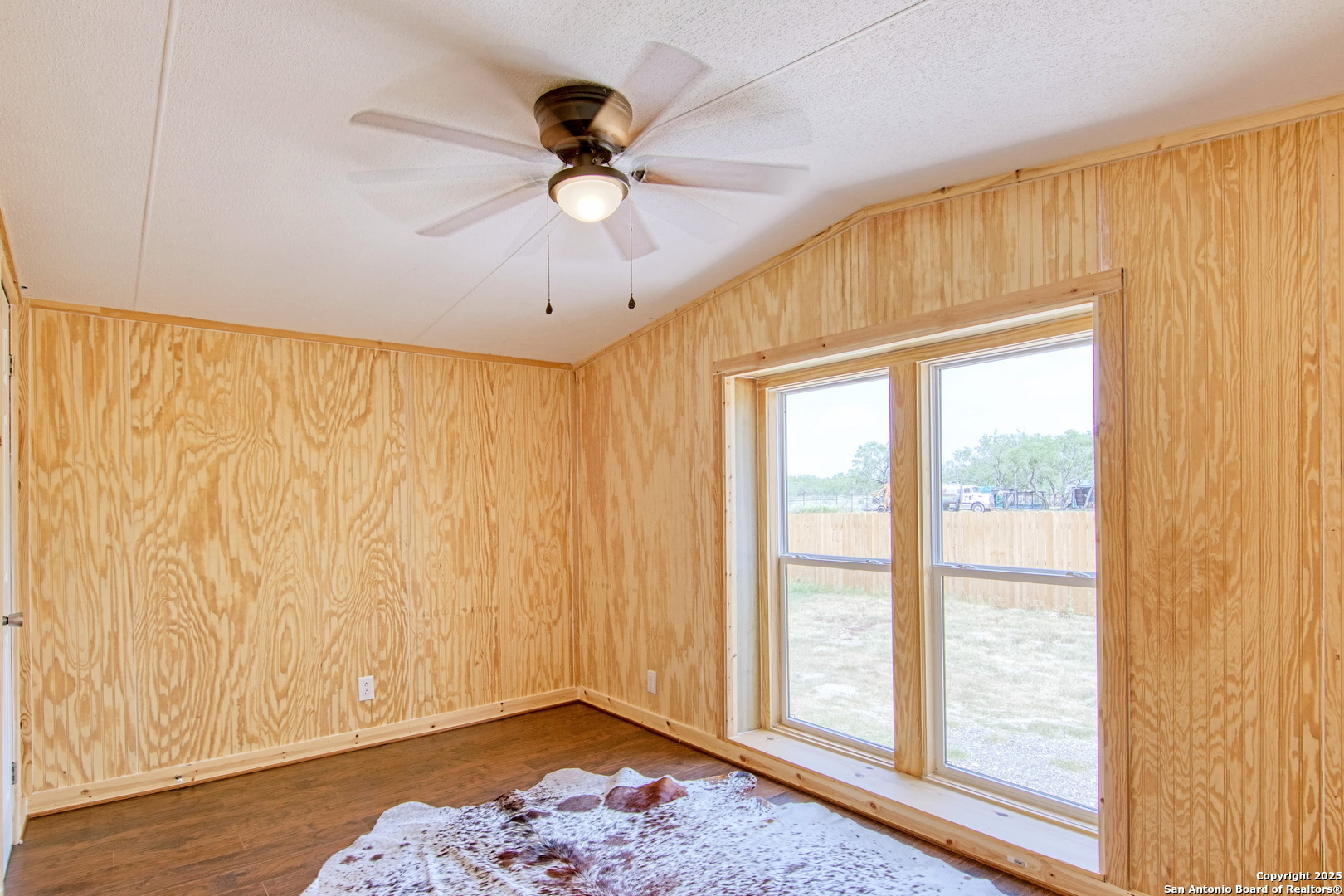 18883 La Gloria Road Elmendorf, TX 78112 - Photo 25 of 46 a view of an empty room with a window and wooden floor
