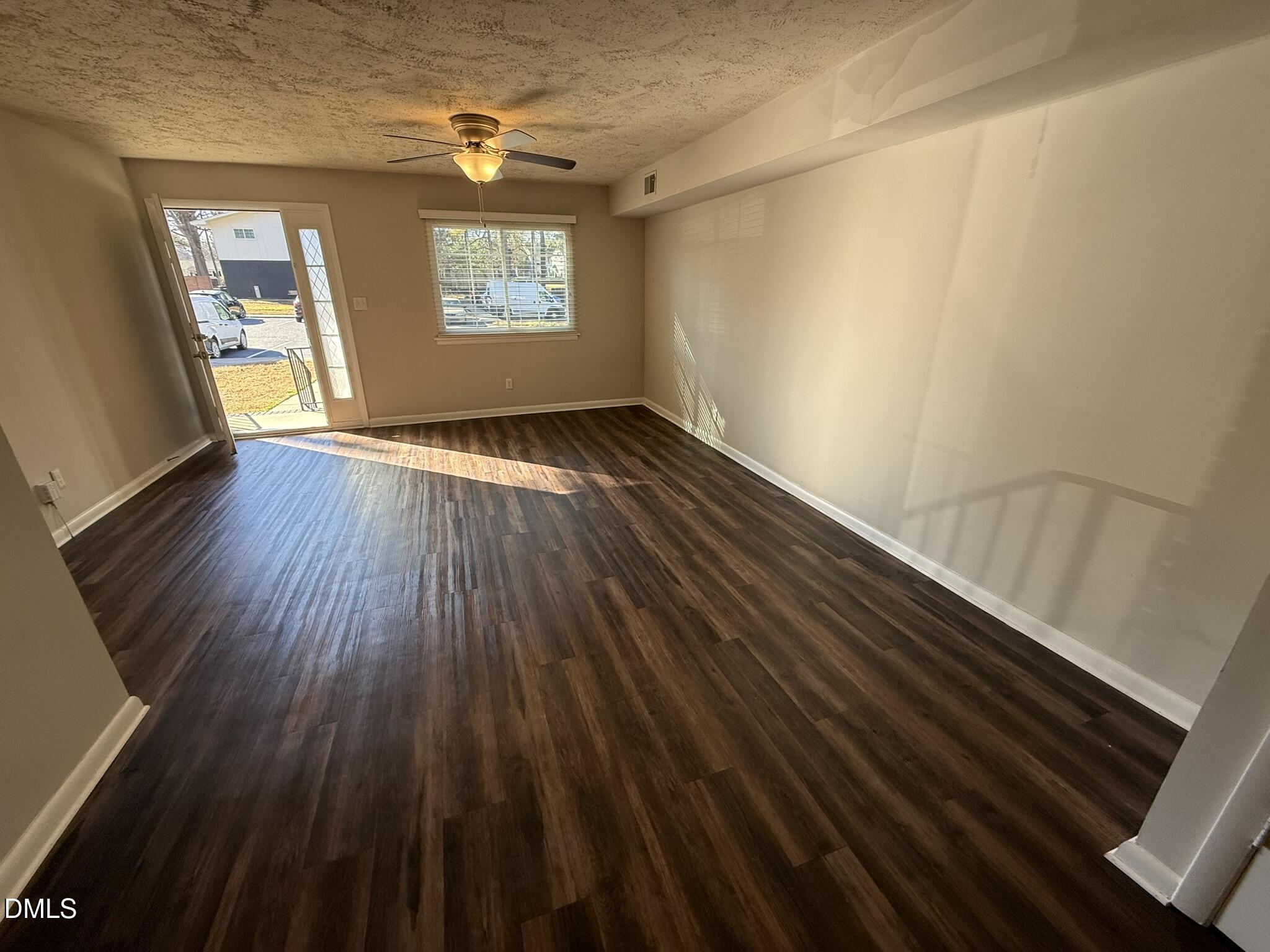 2616 Noble Road, Unit C Raleigh, NC 27608 - Photo 2 of 11 a view of an empty room with wooden floor and a window