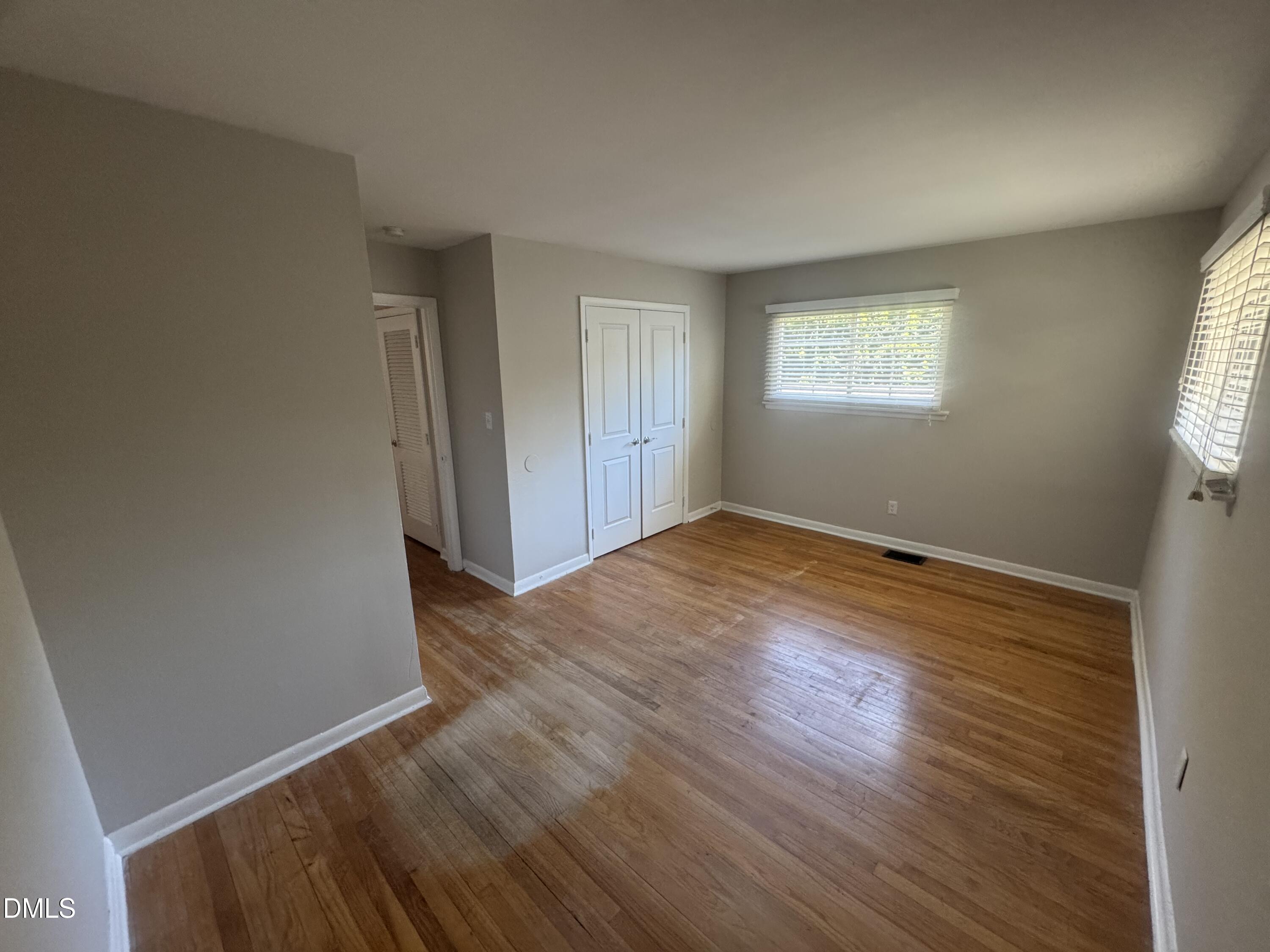 2604 Noble Road, Unit C Raleigh, NC 27608 - Photo 2 of 7 an empty room with wooden floor and windows