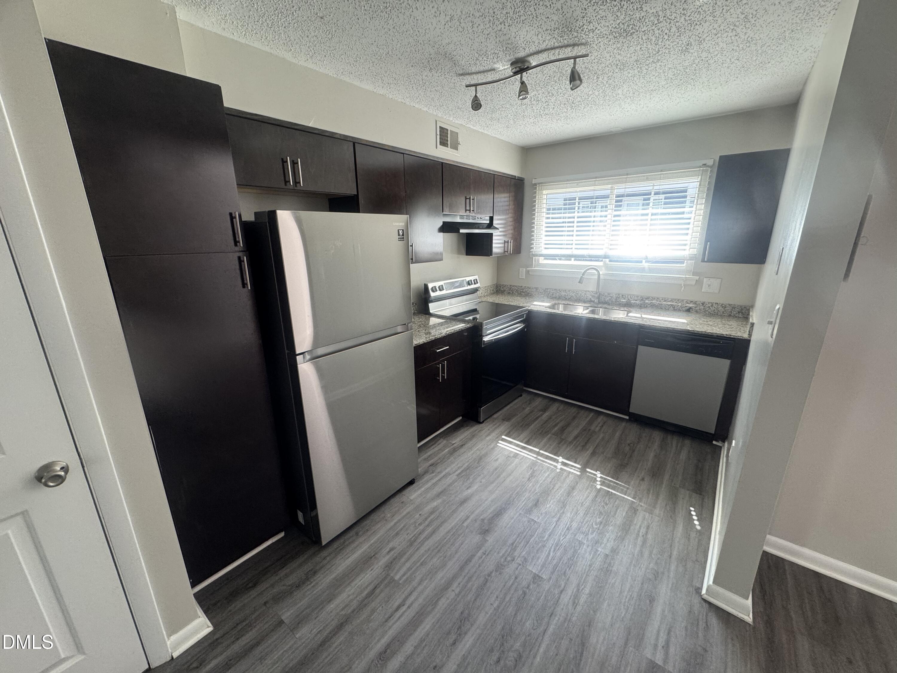 2604 Noble Road, Unit C Raleigh, NC 27608 - Photo 5 of 7 a kitchen with stainless steel appliances a refrigerator a sink a stove a refrigerator and cabinets