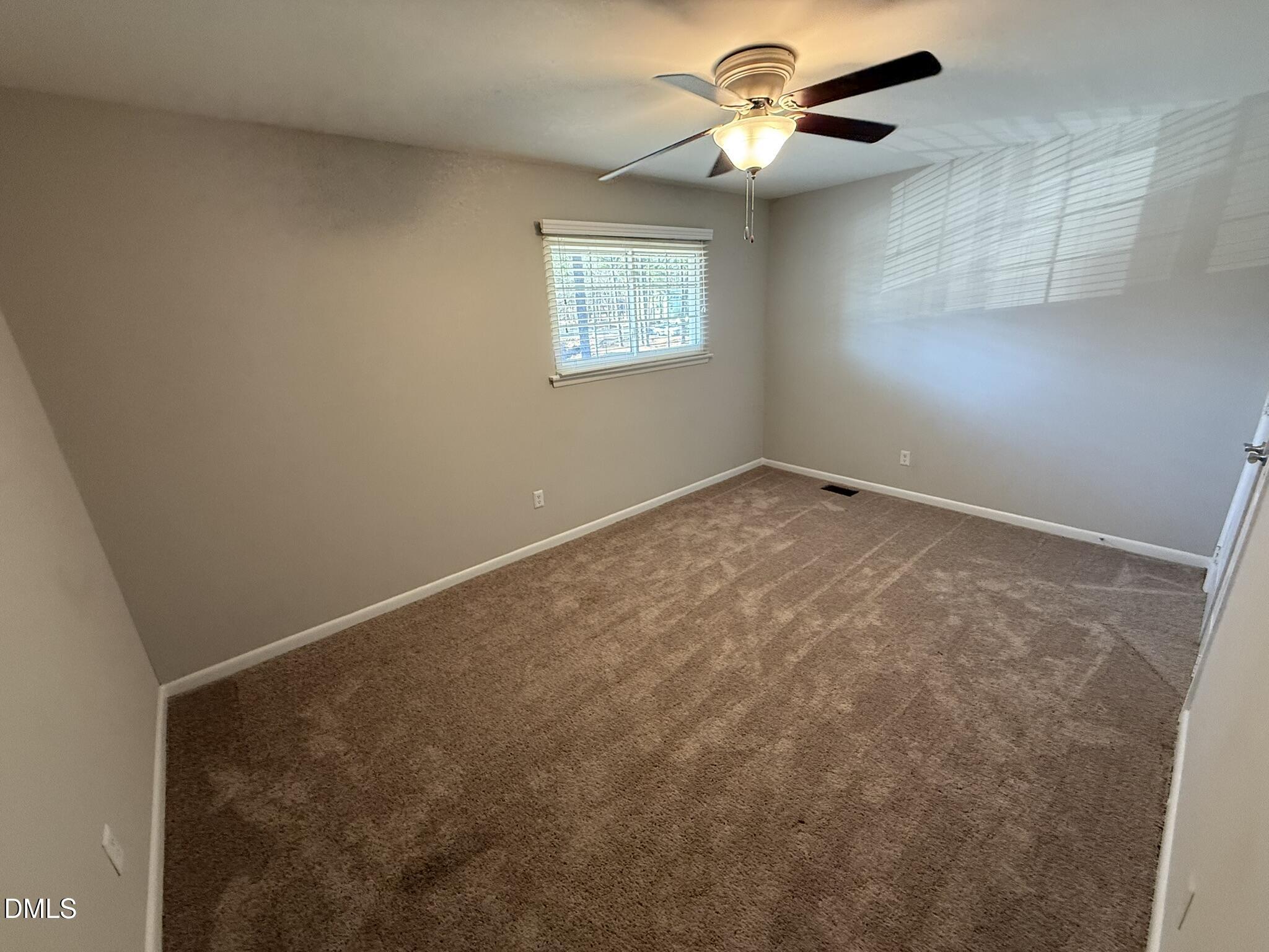 2616 Noble Road, Unit C Raleigh, NC 27608 - Photo 6 of 11 an empty room with a window and a fan