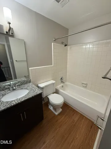a bathroom with a granite countertop sink toilet a mirror and shower
