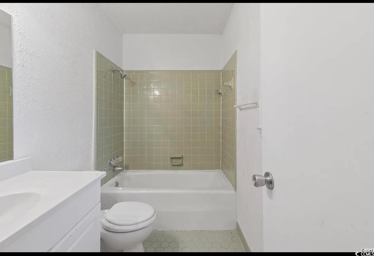1025 Carolina Road, Unit H4 Conway, SC 29526 - Photo 4 of 10 Bathroom featuring shower / washtub combination, vanity, tile patterned flooring, and a textured wall