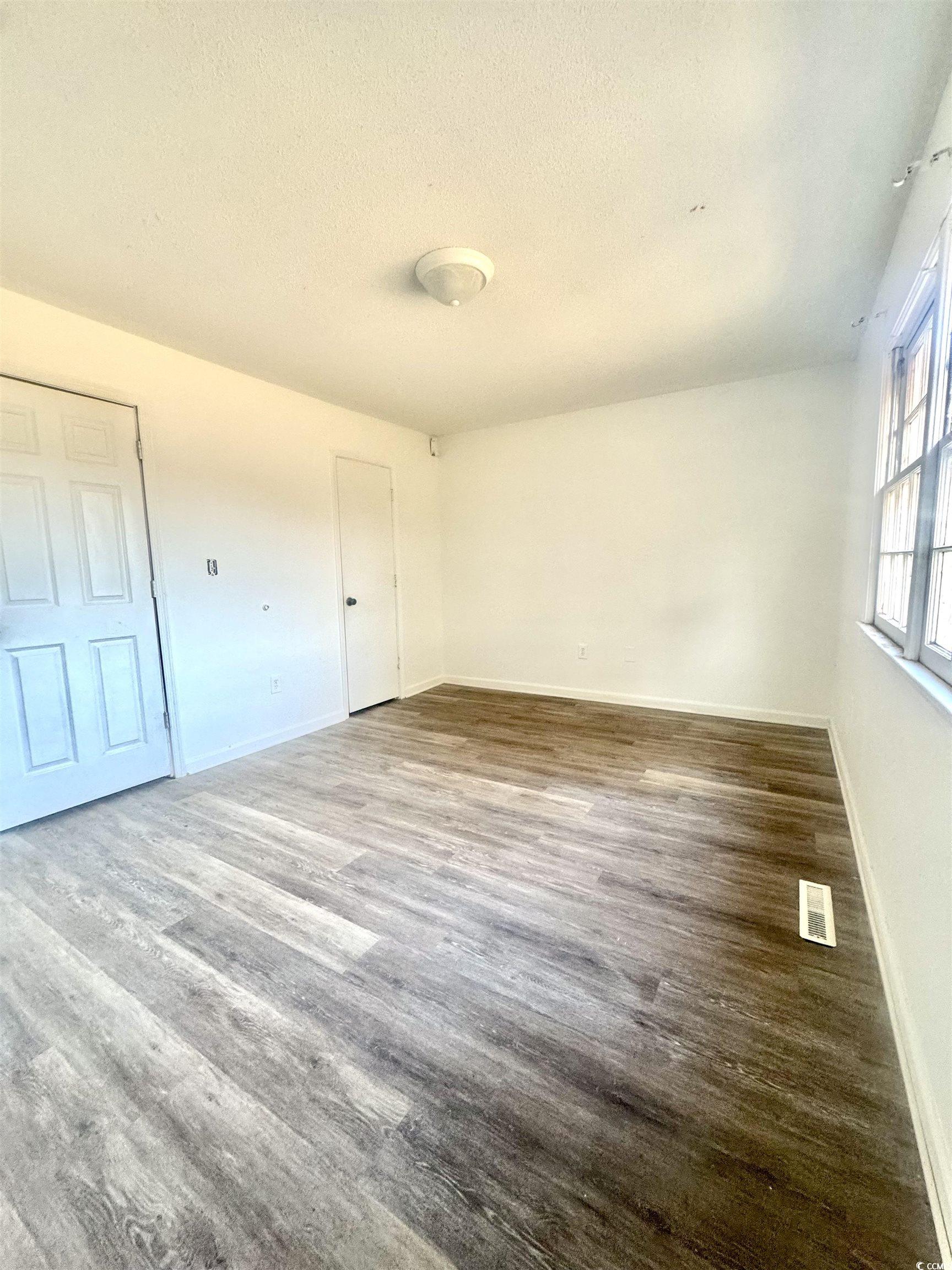 1025 Carolina Road, Unit H4 Conway, SC 29526 - Photo 8 of 10 Spare room featuring wood finished floors and a textured ceiling
