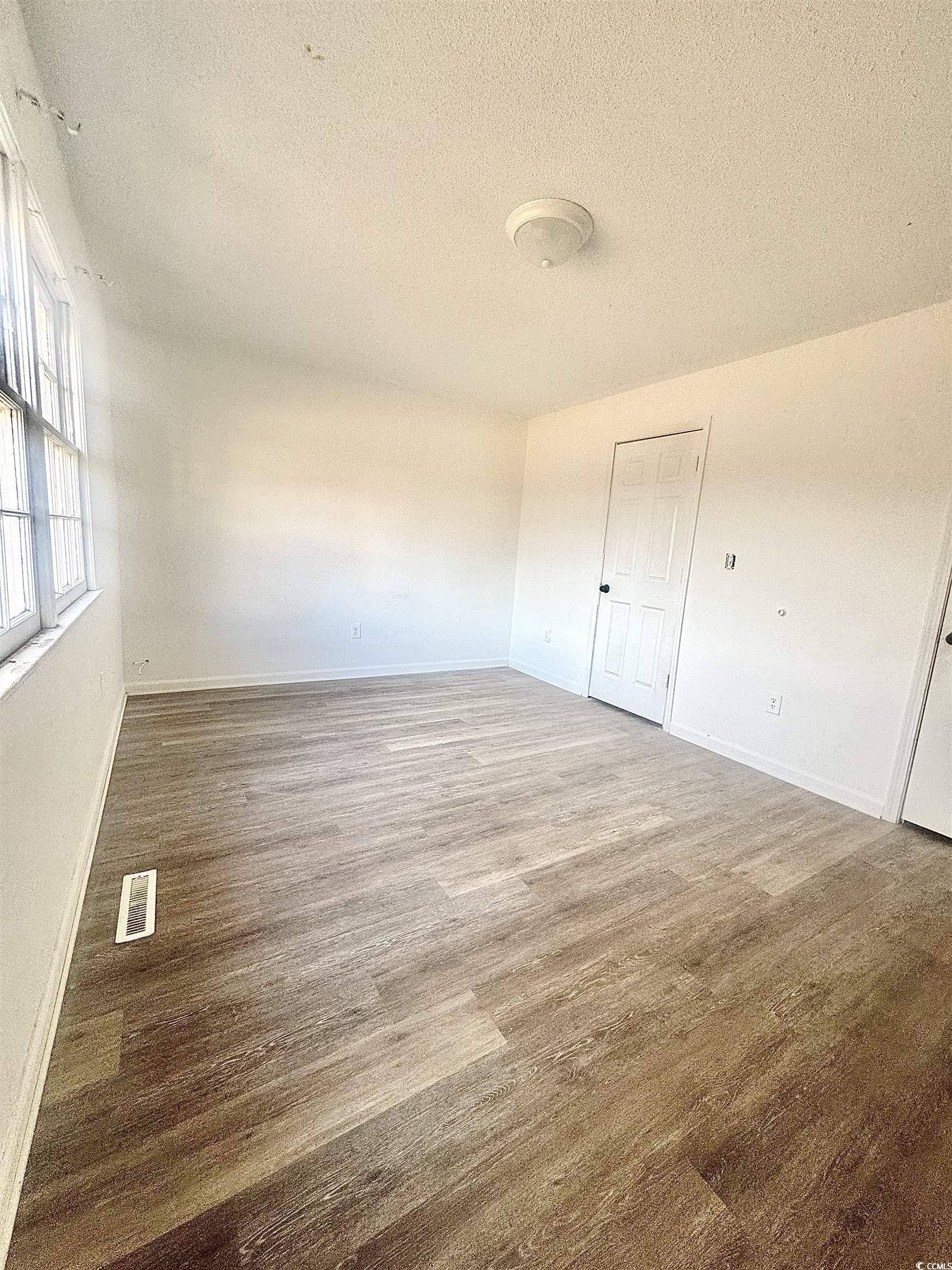 1025 Carolina Road, Unit H4 Conway, SC 29526 - Photo 9 of 10 Spare room with wood finished floors and a textured ceiling