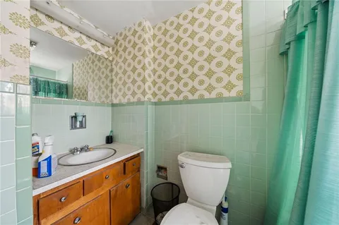 a bathroom with a granite countertop sink mirror vanity and toilet