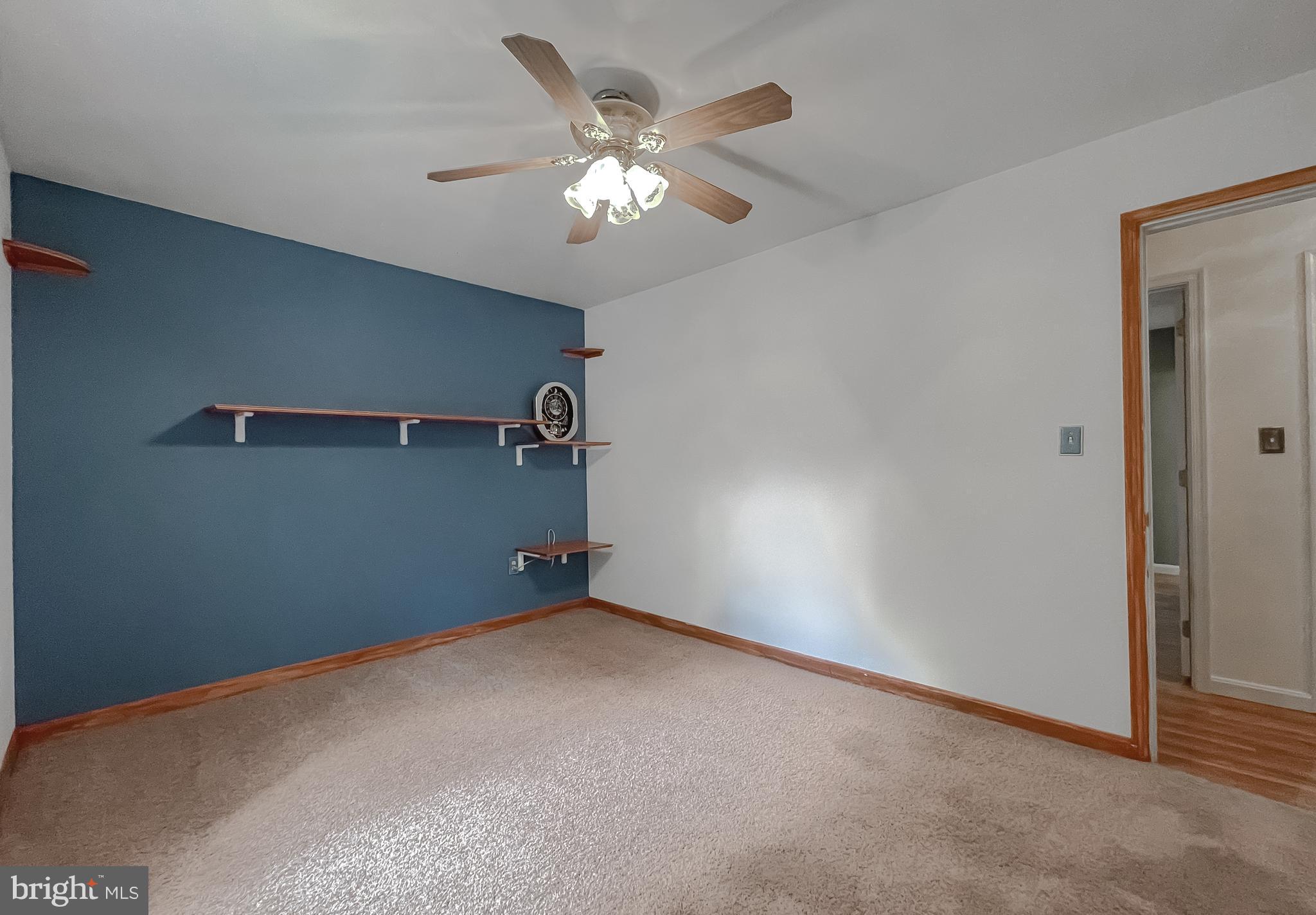 11517 Wrangler Road Lusby, MD 20657 - Photo 16 of 52 an empty room with a chandelier fan and windows