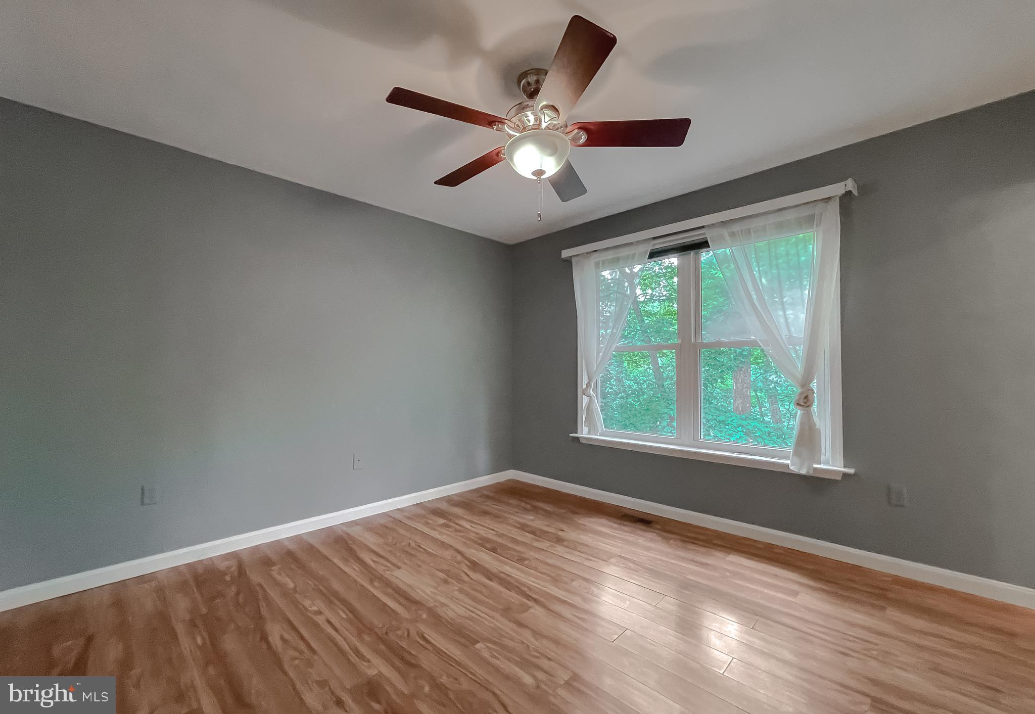 11517 Wrangler Road Lusby, MD 20657 - Photo 23 of 52 a view of an empty room with wooden floor and a window