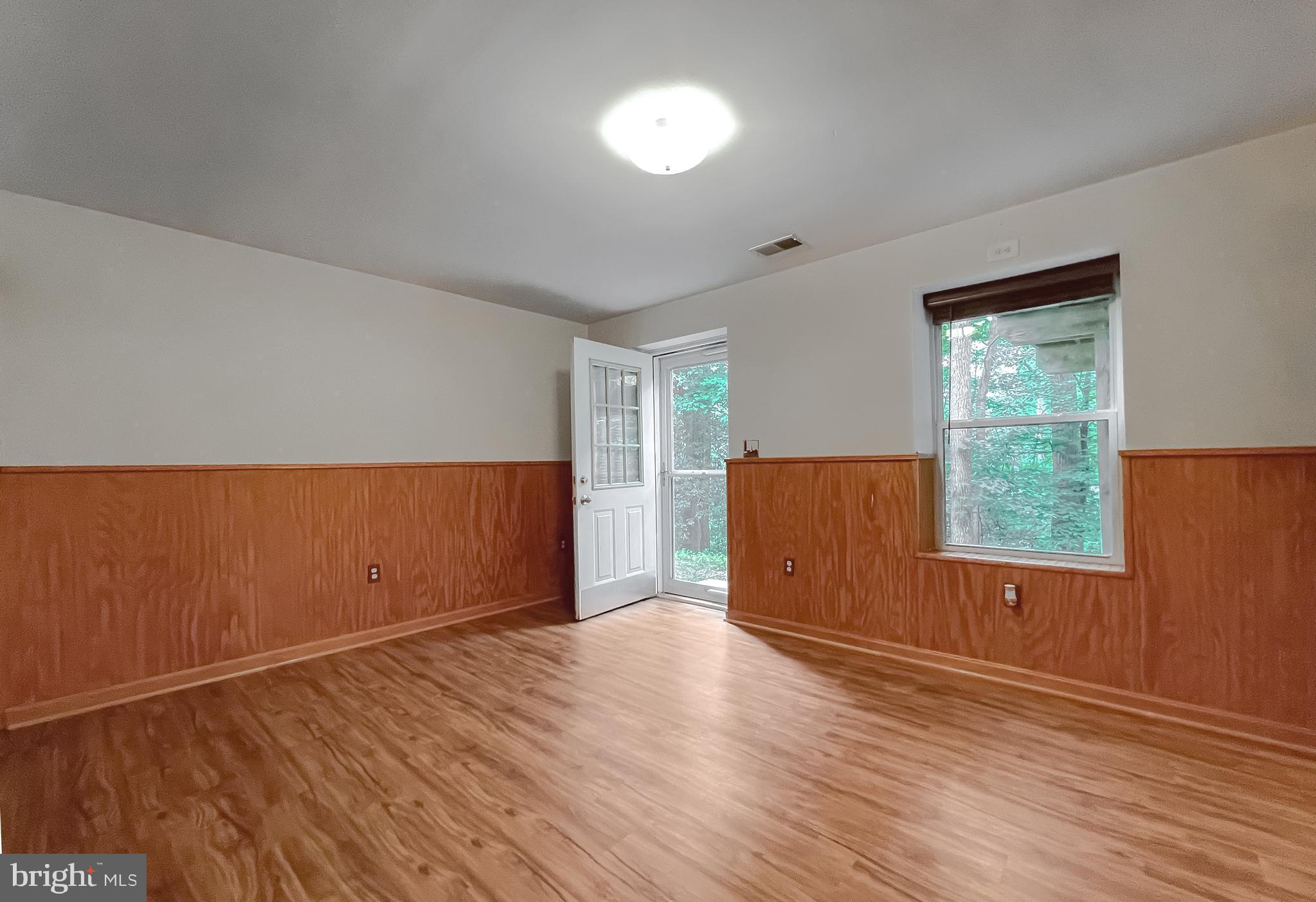 11517 Wrangler Road Lusby, MD 20657 - Photo 36 of 52 an empty room with wooden floor and windows