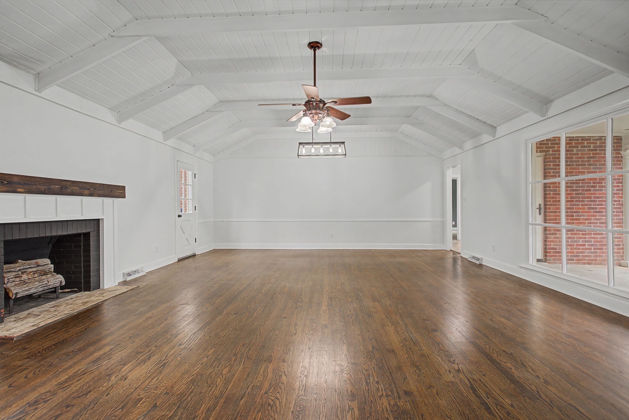 107 Cherry Street Centerville, TN 37033 - Photo 9 of 33 an empty room with wooden floor fireplace and windows