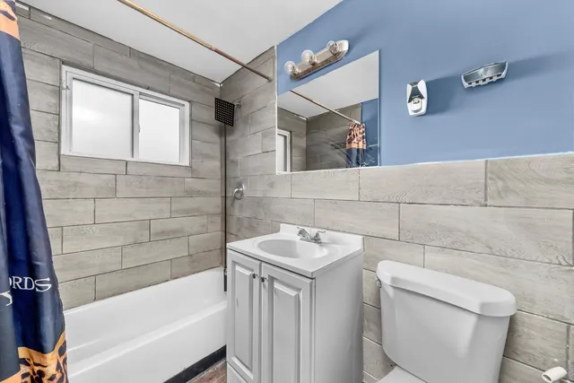 a bathroom with a sink and bathtub with toilet