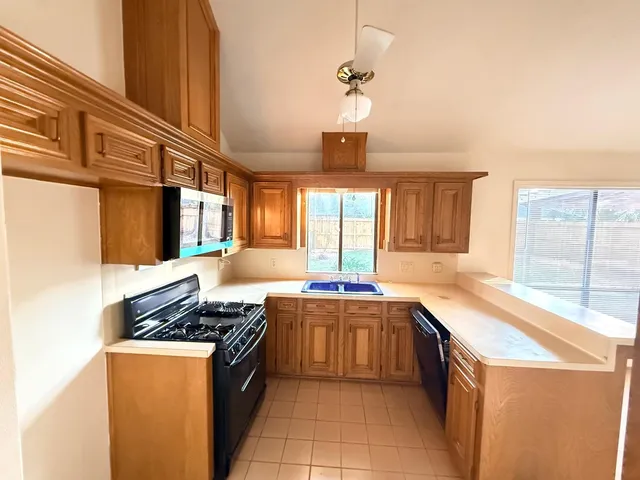 a kitchen with stainless steel appliances granite countertop a sink and a stove