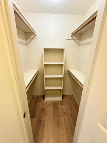 a view of walk in closet with empty racks