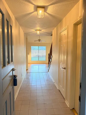 a hallway with sliding door and chandelier