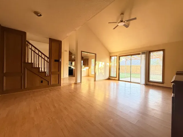 a view of an empty room with a window and wooden floor