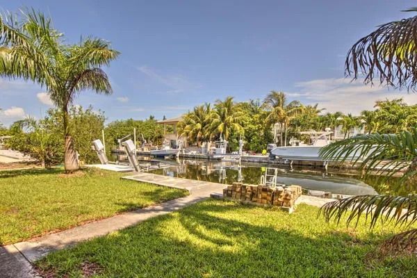 a view of a swimming pool with a yard and plants