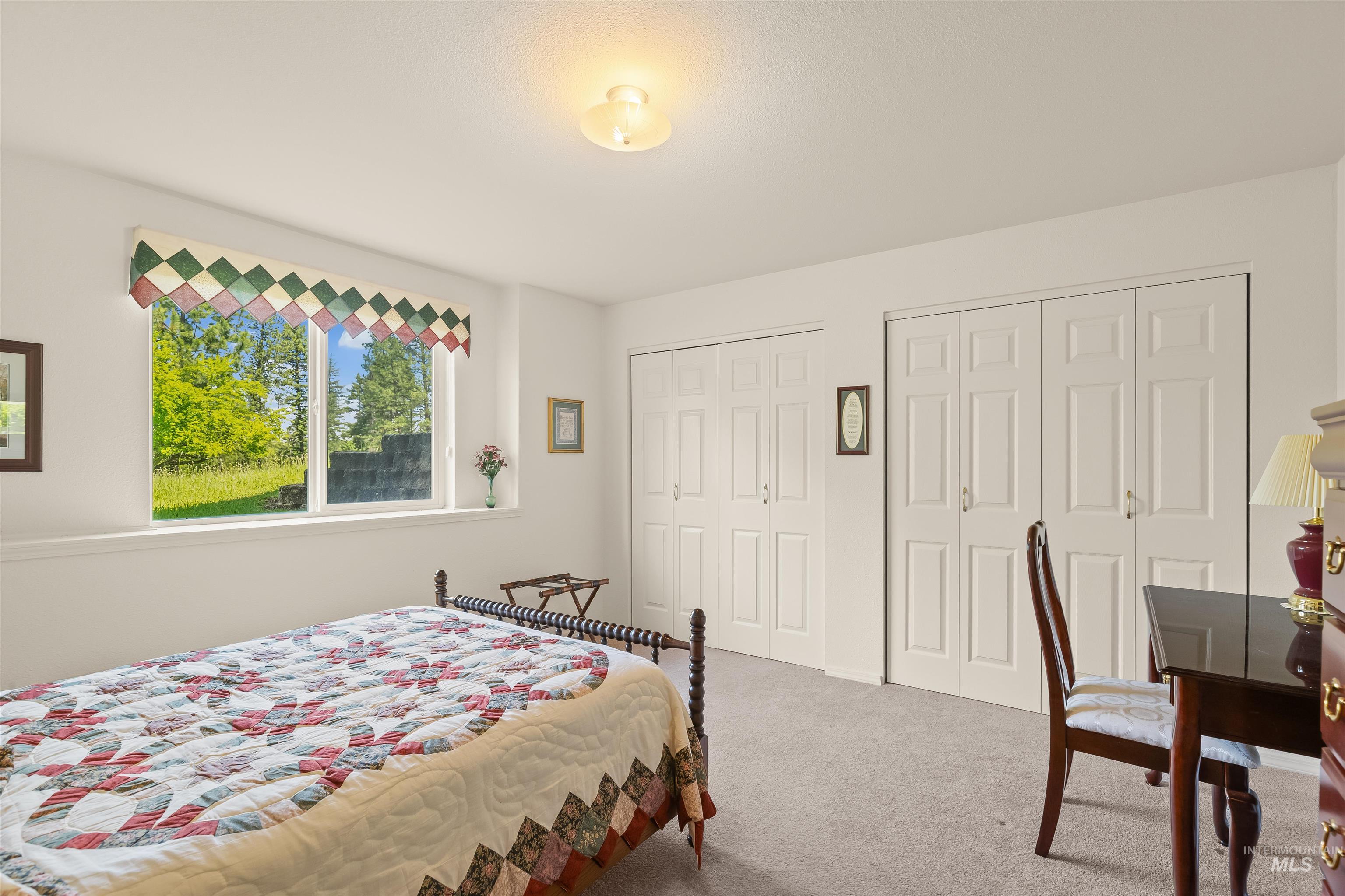 743 Wall Crk Road Stites, ID 83552 - Photo 42 of 48 Bright room featuring a large window, two sets of bi-fold closet doors, and neutral carpeting
