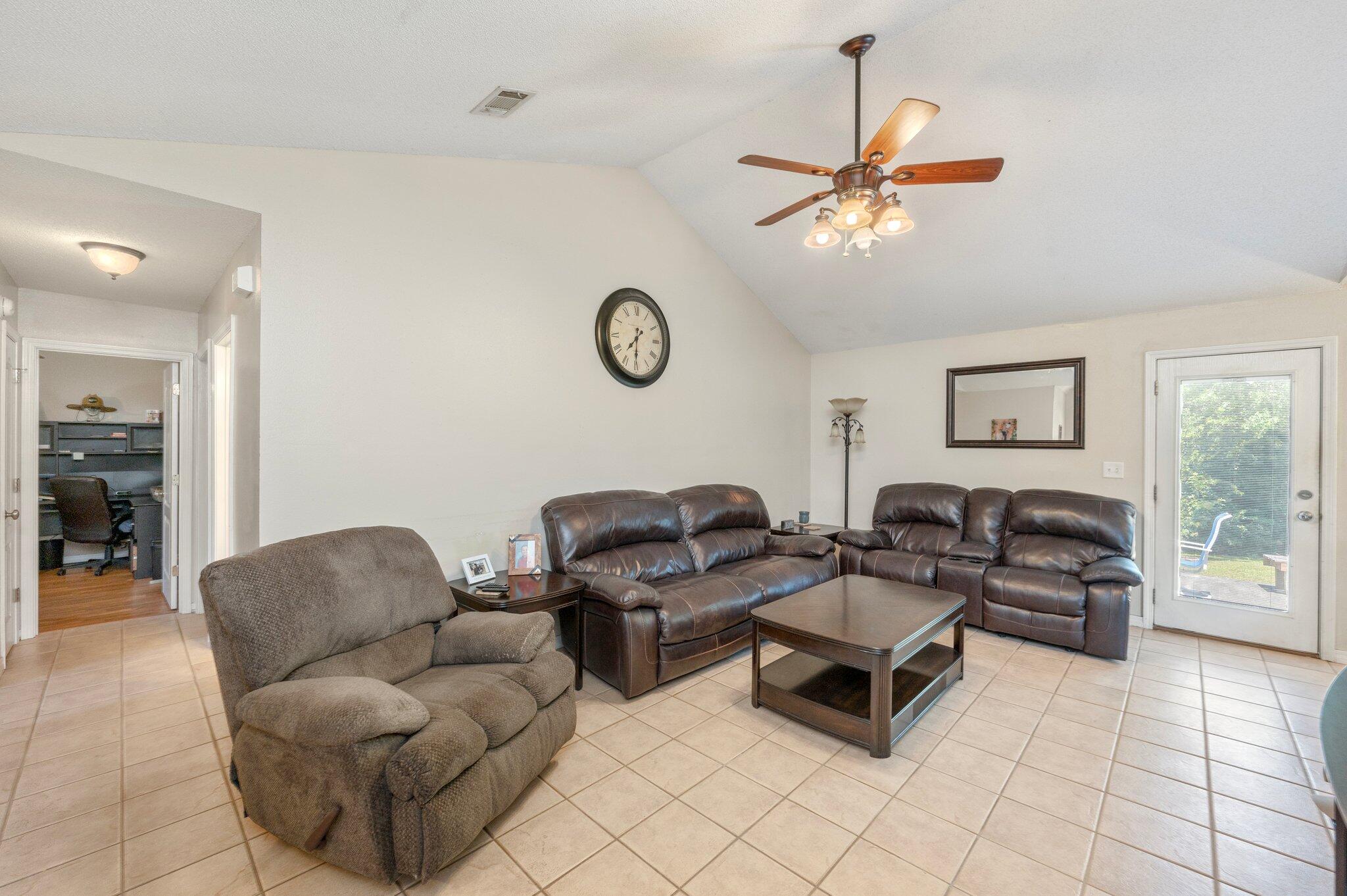 17 Flora Cove Crestview, FL 32539 - Photo 5 of 31 a living room with furniture a clock on wall and a window