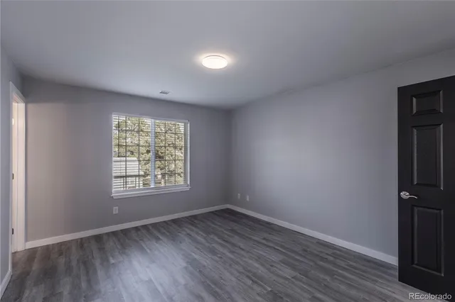 an empty room with wooden floor and window