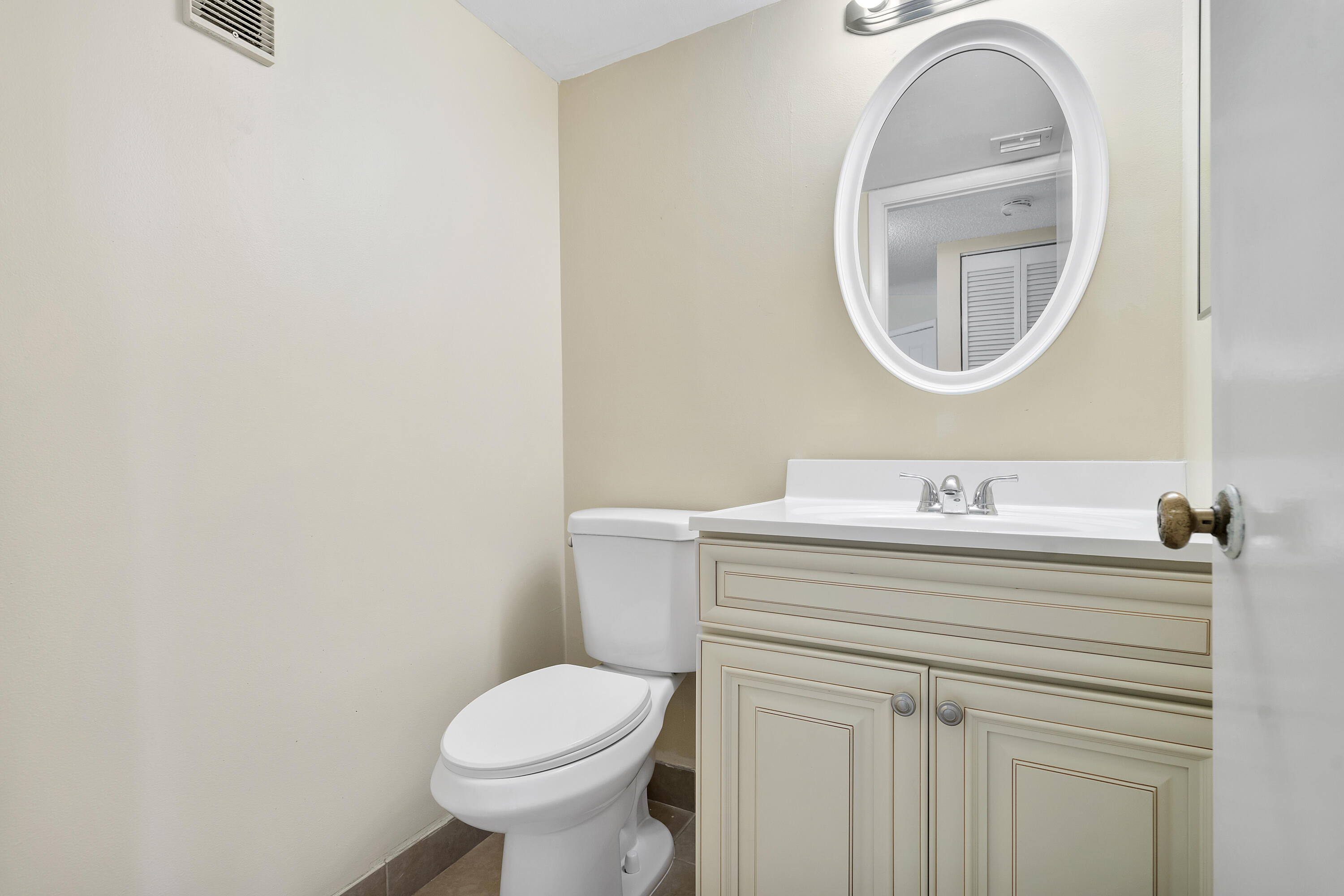 1605 Highway 1, Unit B404 Jupiter, FL 33477 - Photo 11 of 17 a bathroom with a toilet a sink and a mirror