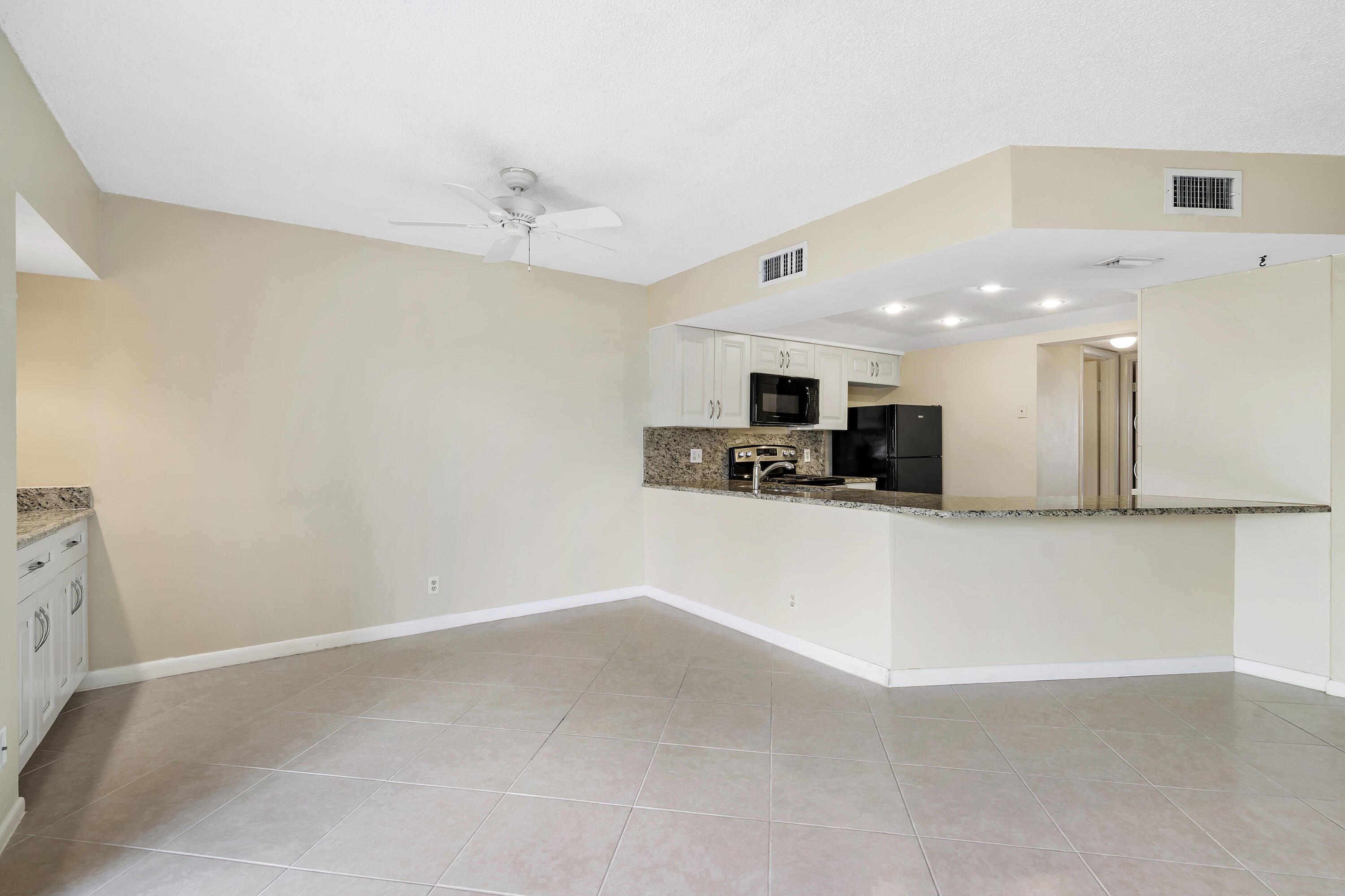 1605 Highway 1, Unit B404 Jupiter, FL 33477 - Photo 2 of 17 a view of a kitchen with a sink and a microwave