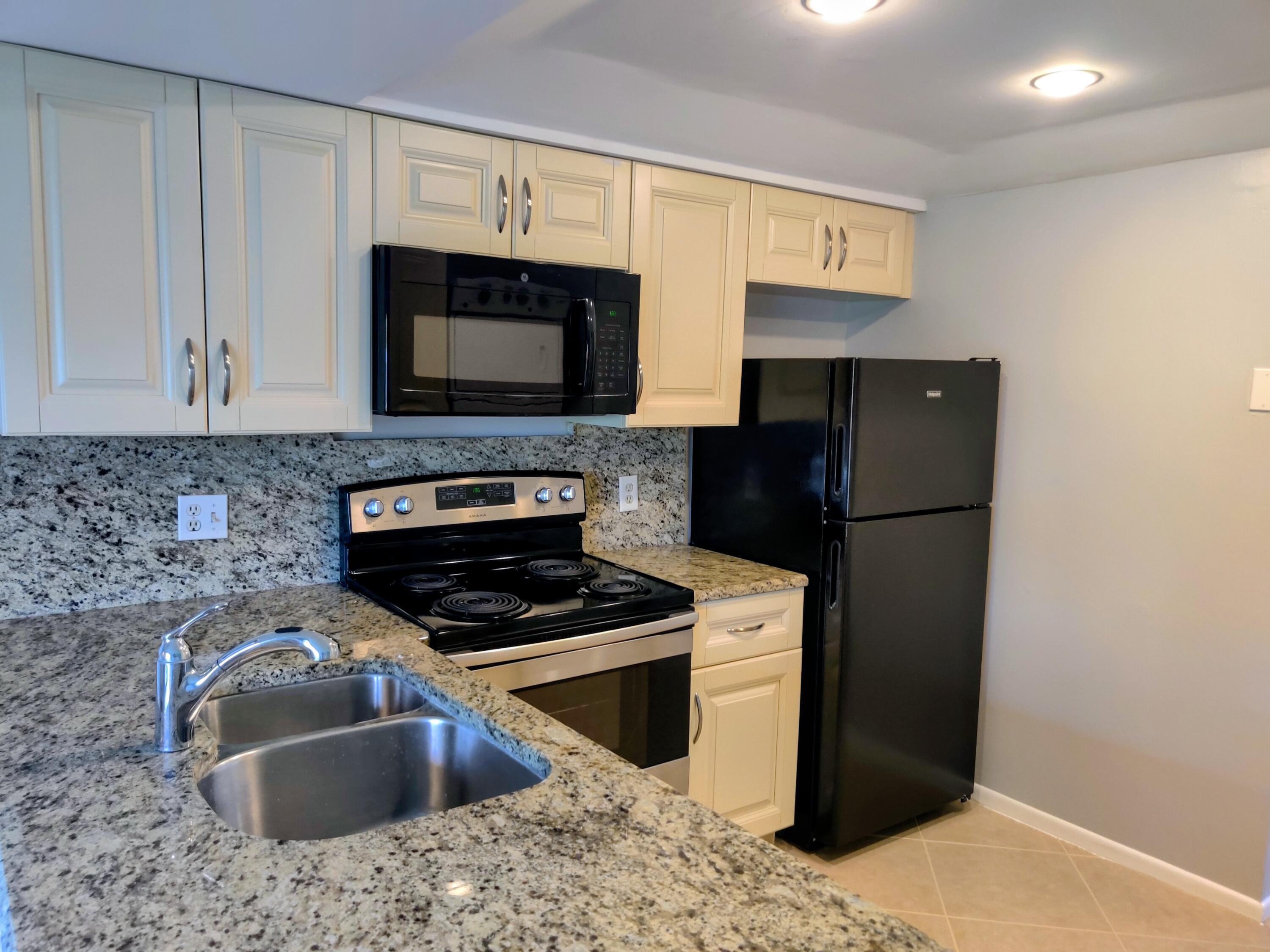 1605 Highway 1, Unit B404 Jupiter, FL 33477 - Photo 4 of 17 a kitchen with a sink stove and refrigerator