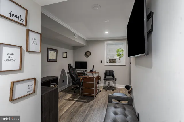 a view of a workspace with furniture and a flat screen tv