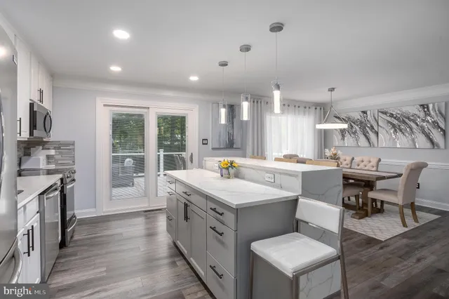 a large white kitchen with a stove a sink a refrigerator and island