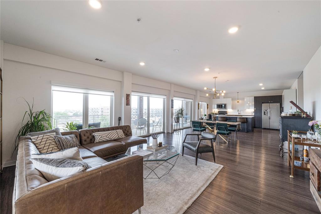 a living room with lots of furniture and view of kitchen