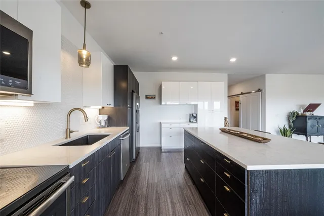 a kitchen with granite countertop a sink stainless steel appliances and cabinets