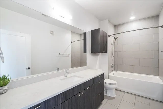 a bathroom with a bathtub shower sink mirror and toilet