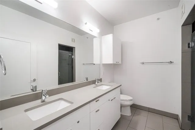 a bathroom with a granite countertop sink a toilet and a mirror