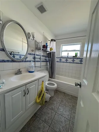 a bathroom with a double vanity sink toilet mirror and bathtub