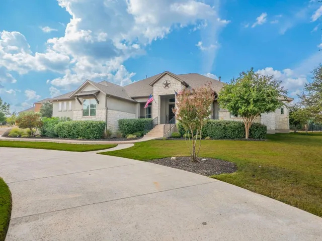 a view of a house with a big yard and large trees