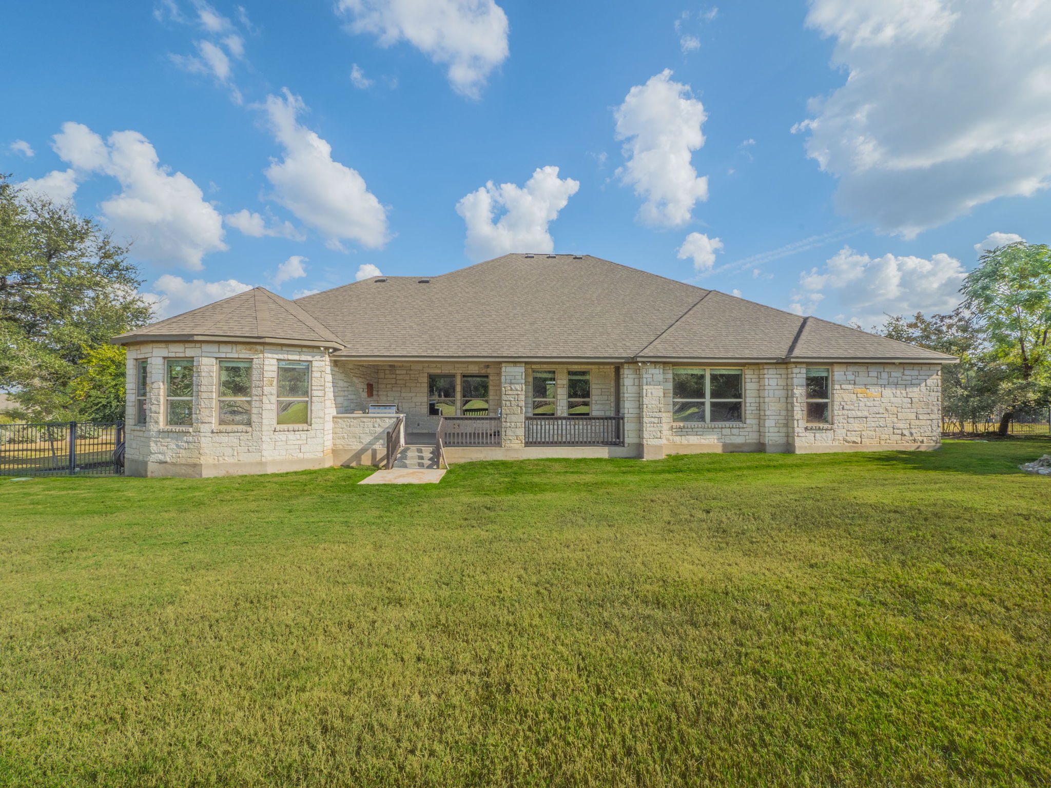 205 Standing Oak Drive Georgetown, TX 78633 - Photo 32 of 40 Back of property featuring a patio, roof with shingles, and stone siding
