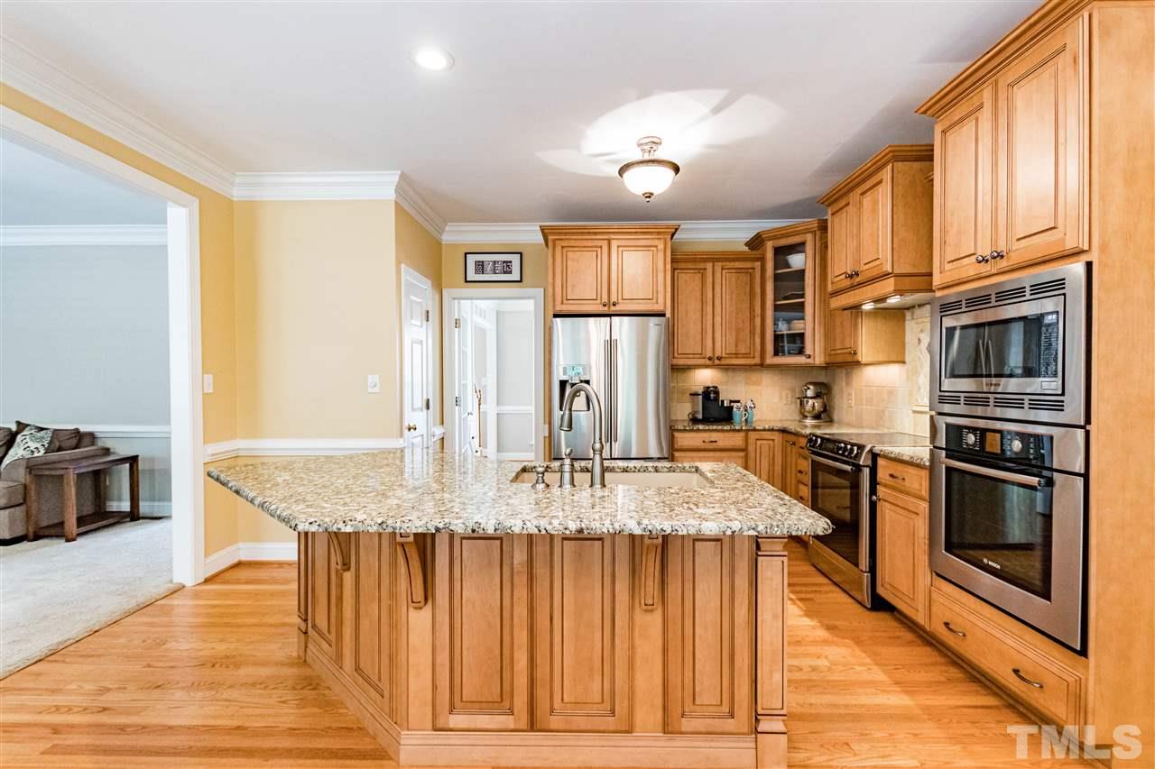 8108 Fallston Court Raleigh, NC 27613 - Photo 6 of 23 a kitchen with stainless steel appliances granite countertop a stove top oven a refrigerator a sink and dishwasher with wooden floor