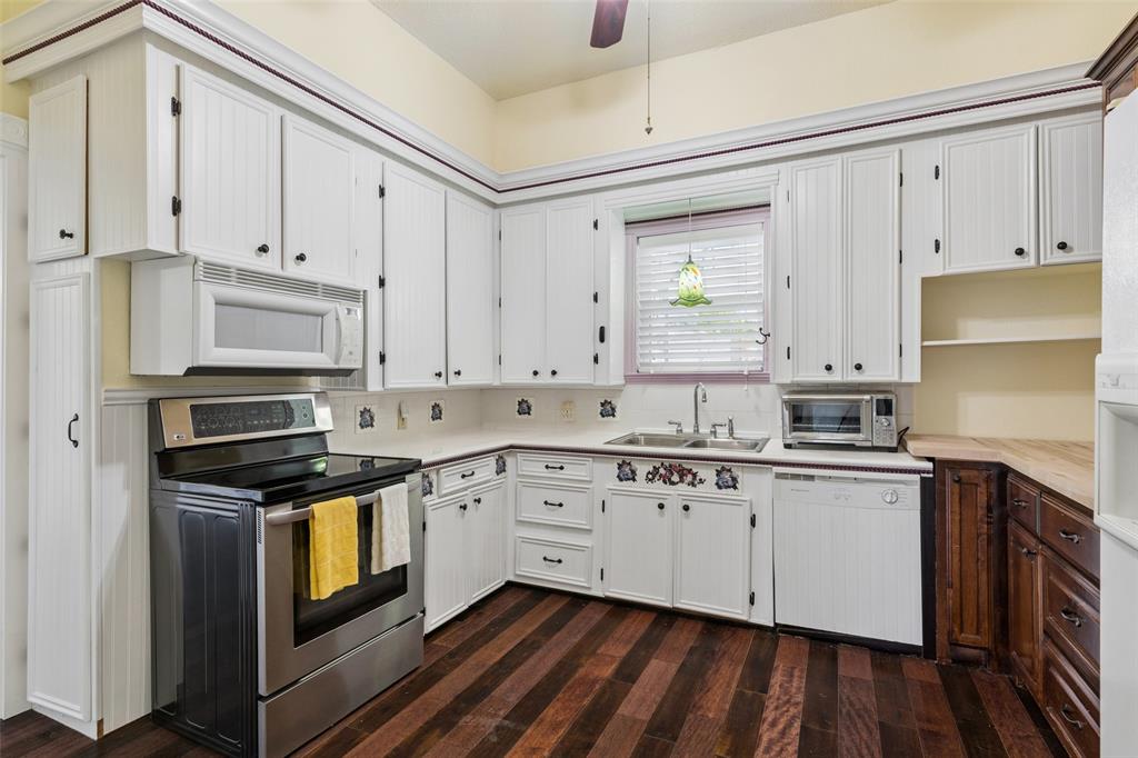 5824 Boone Street Sachse, TX 75048 - Photo 12 of 40 a kitchen with granite countertop white cabinets and stainless steel appliances