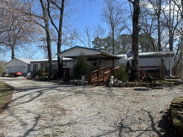 a view of a house with a yard covered with snow and trees